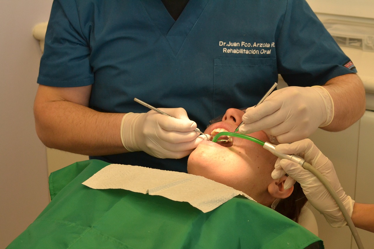 Dentysta Olsztyn podczas konsultacji stomatologicznej z pacjentem w nowoczesnym gabinecie.

